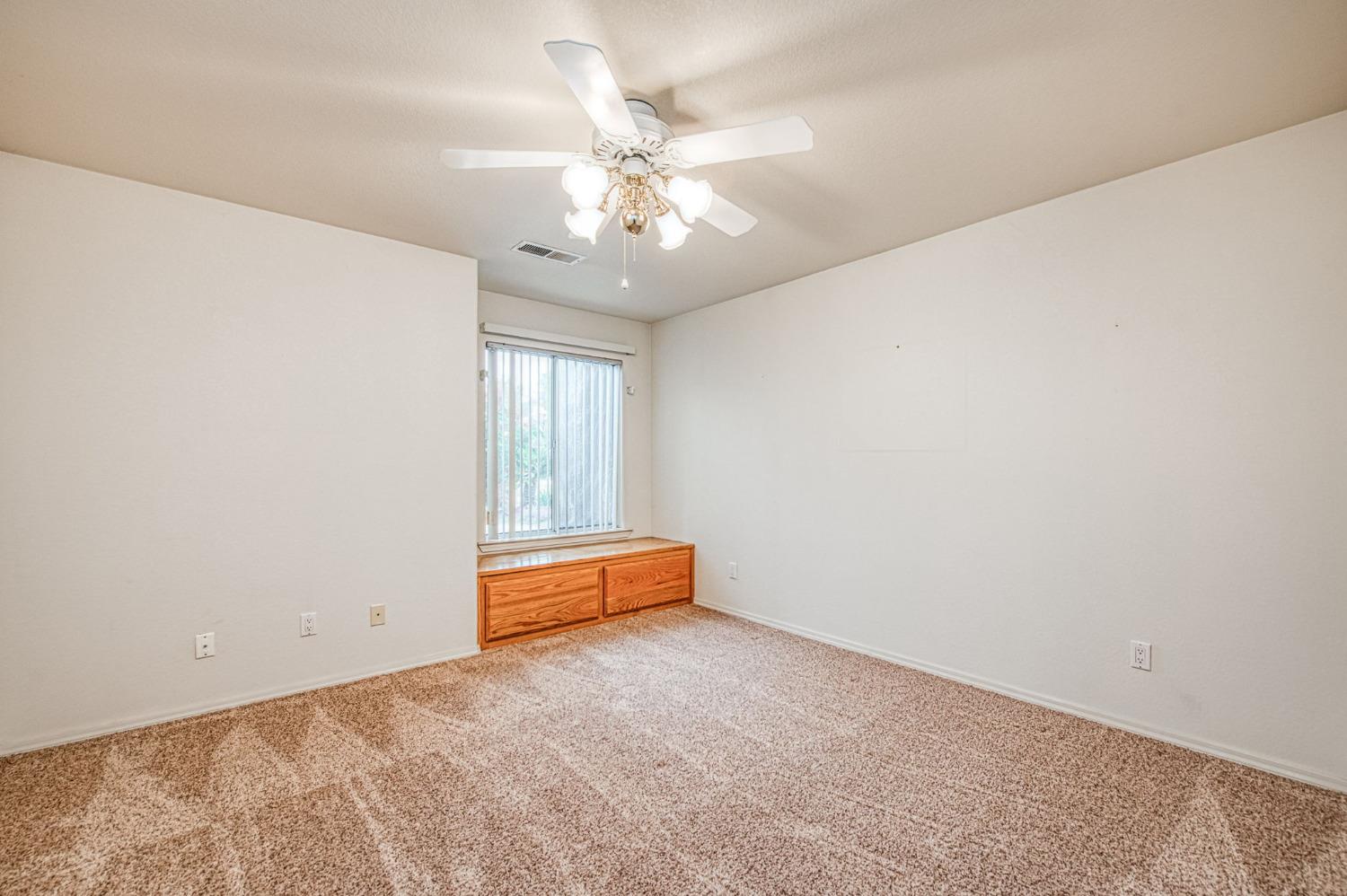 3225 Filbert Avenue Clovis, CA 93611 - Photo 17 of 36 an empty room with chandelier fan and windows