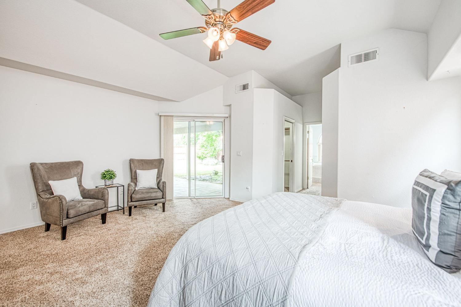 3225 Filbert Avenue Clovis, CA 93611 - Photo 24 of 36 a bedroom with a bed chair and a chandelier