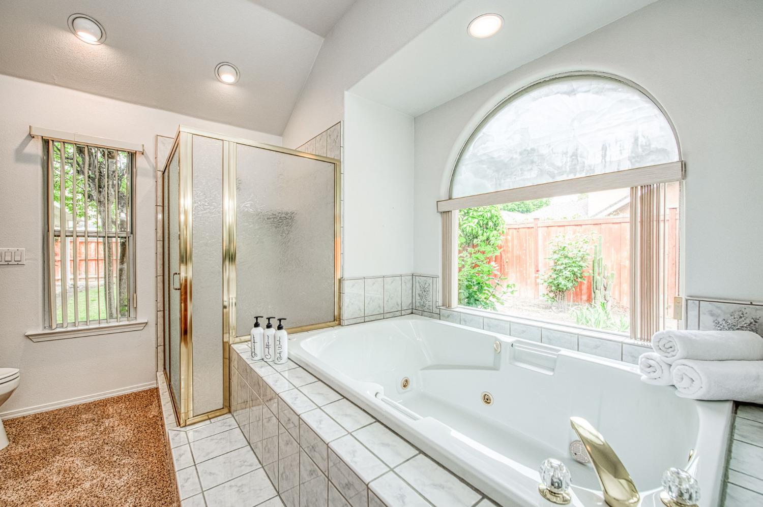 3225 Filbert Avenue Clovis, CA 93611 - Photo 29 of 36 a bathroom with a tub a sink and a large mirror