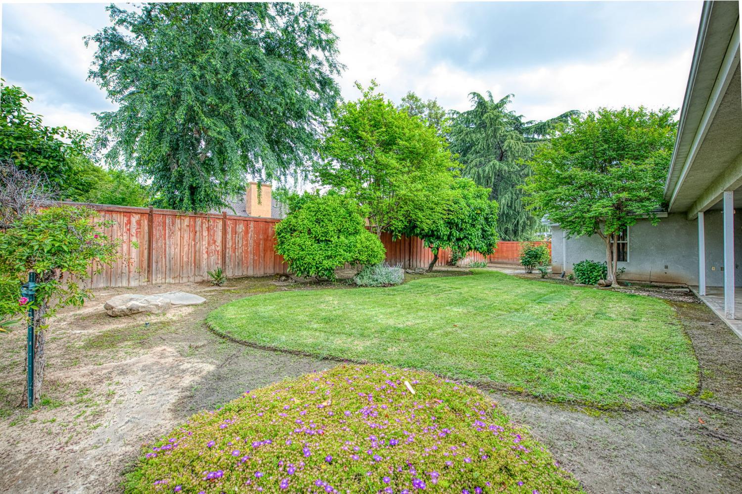 3225 Filbert Avenue Clovis, CA 93611 - Photo 32 of 36 a view of a backyard with table and chairs plants and large tree