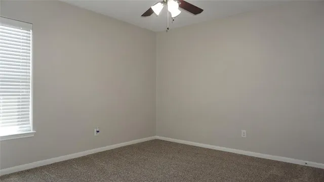 an empty room with a chandelier fan