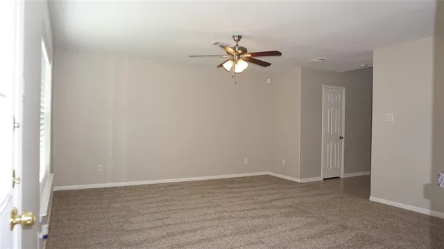 a view of a room with wooden floor and fan