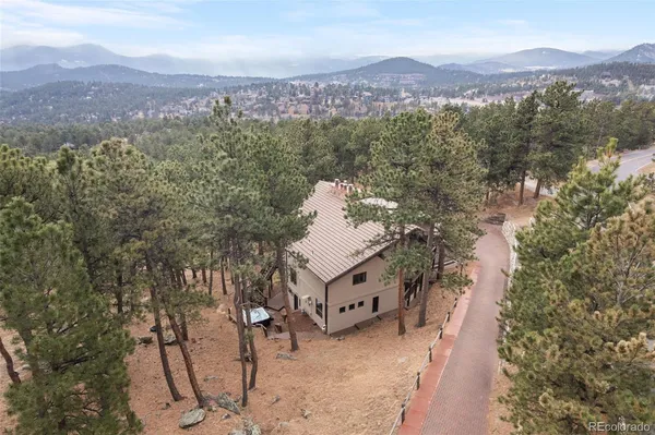 an aerial view of a house with a mountain