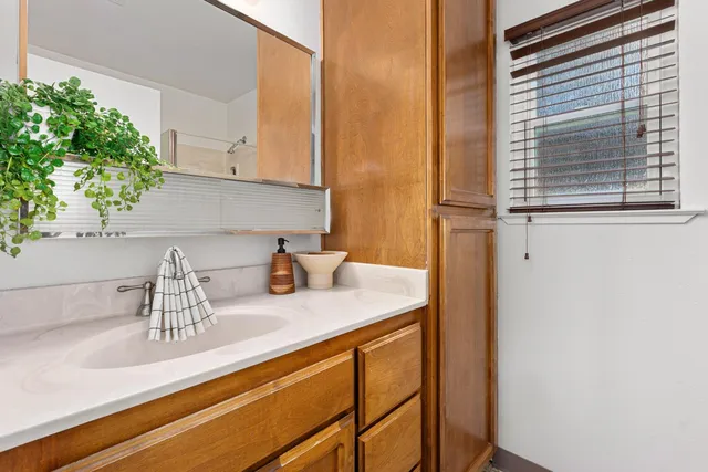 a bathroom with a granite countertop sink toilet and mirror