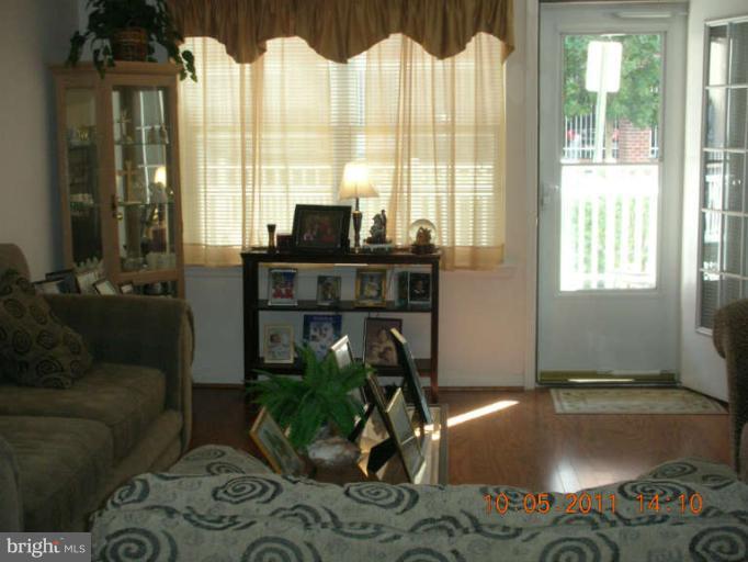 9510 Coyle Road, Unit 201 Owings Mills, MD 21117 - Photo 4 of 14 a living room with furniture and a floor to ceiling window