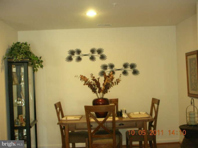 9510 Coyle Road, Unit 201 Owings Mills, MD 21117 - Photo 5 of 14 a view of a dining room with furniture and wooden floor