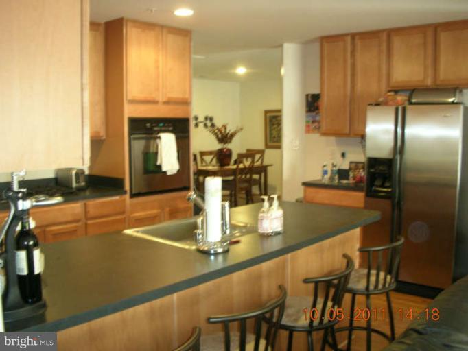 9510 Coyle Road, Unit 201 Owings Mills, MD 21117 - Photo 6 of 14 a kitchen with dining table cabinets and appliances