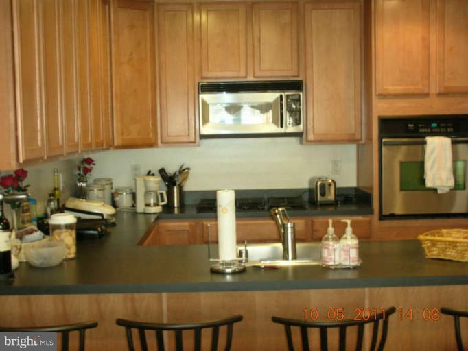 9510 Coyle Road, Unit 201 Owings Mills, MD 21117 - Photo 7 of 14 a kitchen with a sink and cabinets