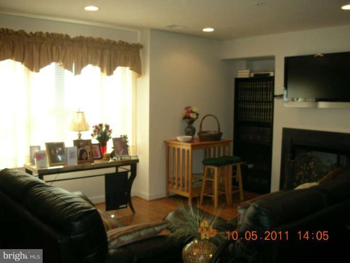 9510 Coyle Road, Unit 201 Owings Mills, MD 21117 - Photo 10 of 14 a living room with furniture a window and a flat screen tv