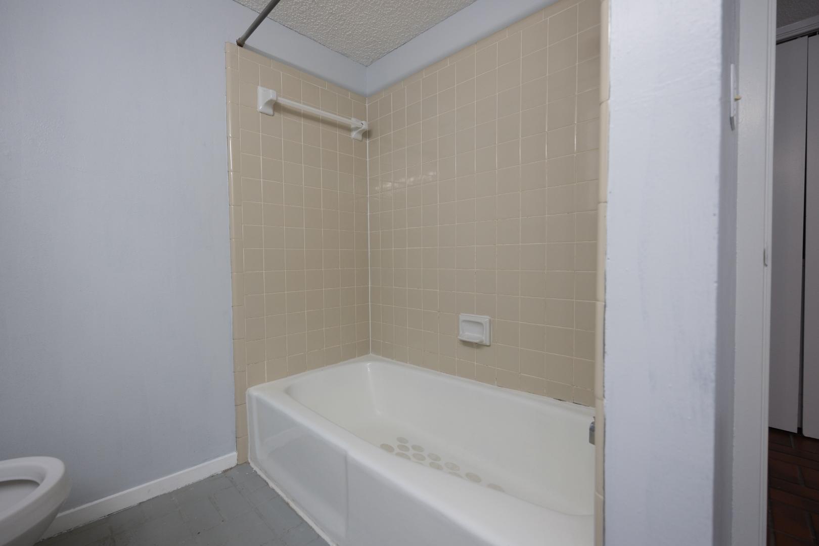 2110 Rio Grande Street, Unit 307 Austin, TX 78705 - Photo 11 of 12 Functional bathroom offering a classic tub and tiled shower surround.