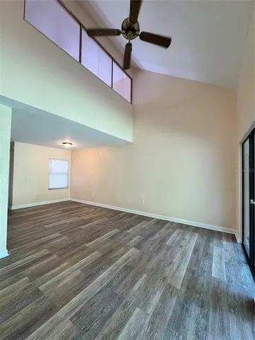 a view of empty room with wooden floor