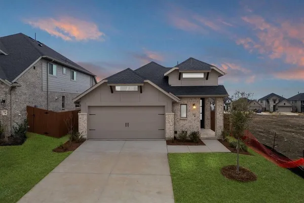 a front view of a house with a garden and plants