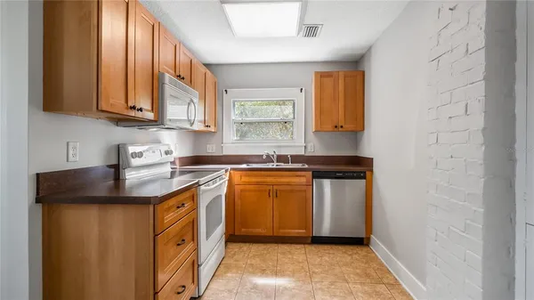 a kitchen with stainless steel appliances granite countertop a sink stove and cabinets