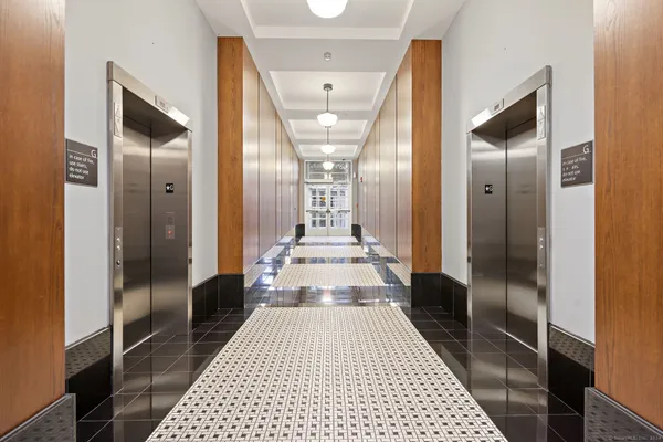 a view of a hallway view with wooden floor and a bathroom