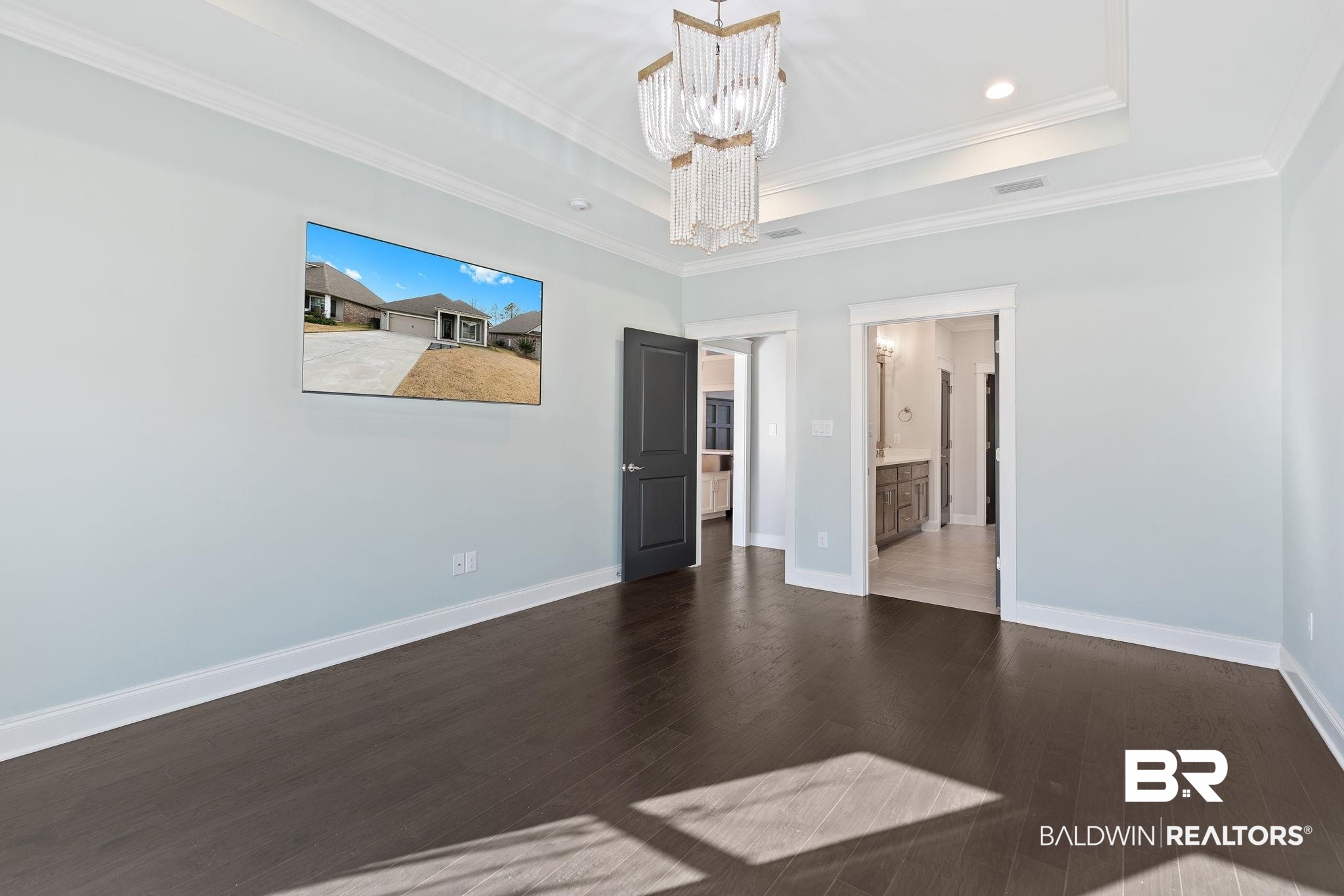 31654 Canopy Loop Daphne, AL 36527 - Photo 30 of 64 Unfurnished bedroom featuring suspended lighting, dark wood finished floors, ornamental molding, ensuite bathroom, and a tray ceiling