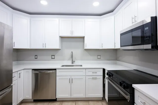 a kitchen with stainless steel appliances granite countertop a sink and a stove