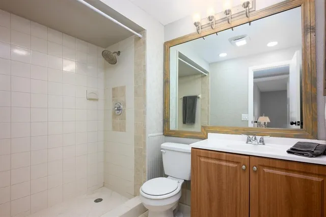 a bathroom with a granite countertop sink toilet and shower