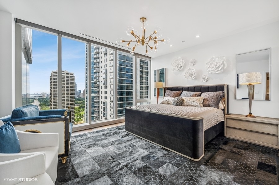 363 East Wacker Drive, Unit 2103 Chicago, IL 60601 - Photo 12 of 19 a bedroom with a large bed and a chandelier