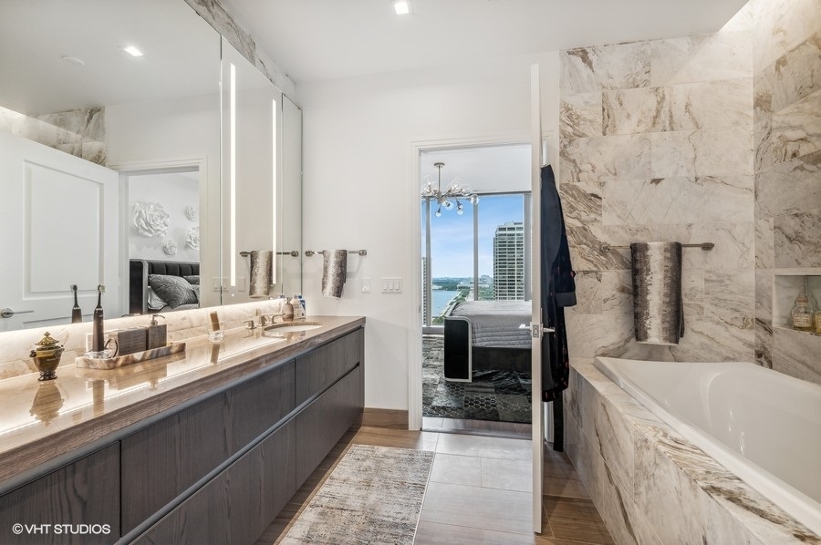 363 East Wacker Drive, Unit 2103 Chicago, IL 60601 - Photo 15 of 19 a large bathroom with a double vanity sink a mirror and a bathtub