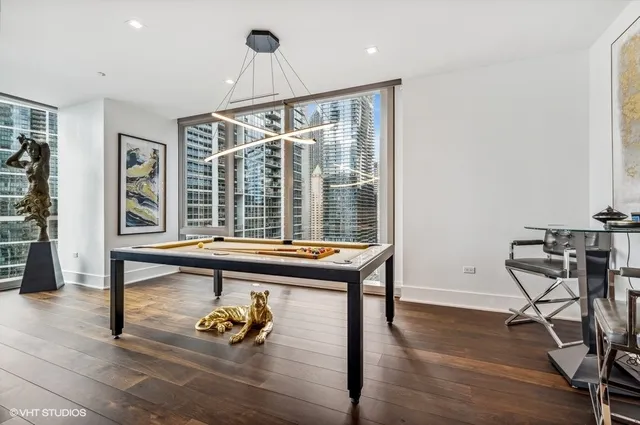 a large kitchen with kitchen island a stove a sink a refrigerator and white cabinets with wooden floor