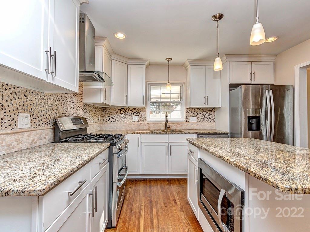 259 North Sharon Amity Road Charlotte, NC 28211 - Photo 11 of 27 a kitchen with stainless steel appliances granite countertop a sink stove and refrigerator