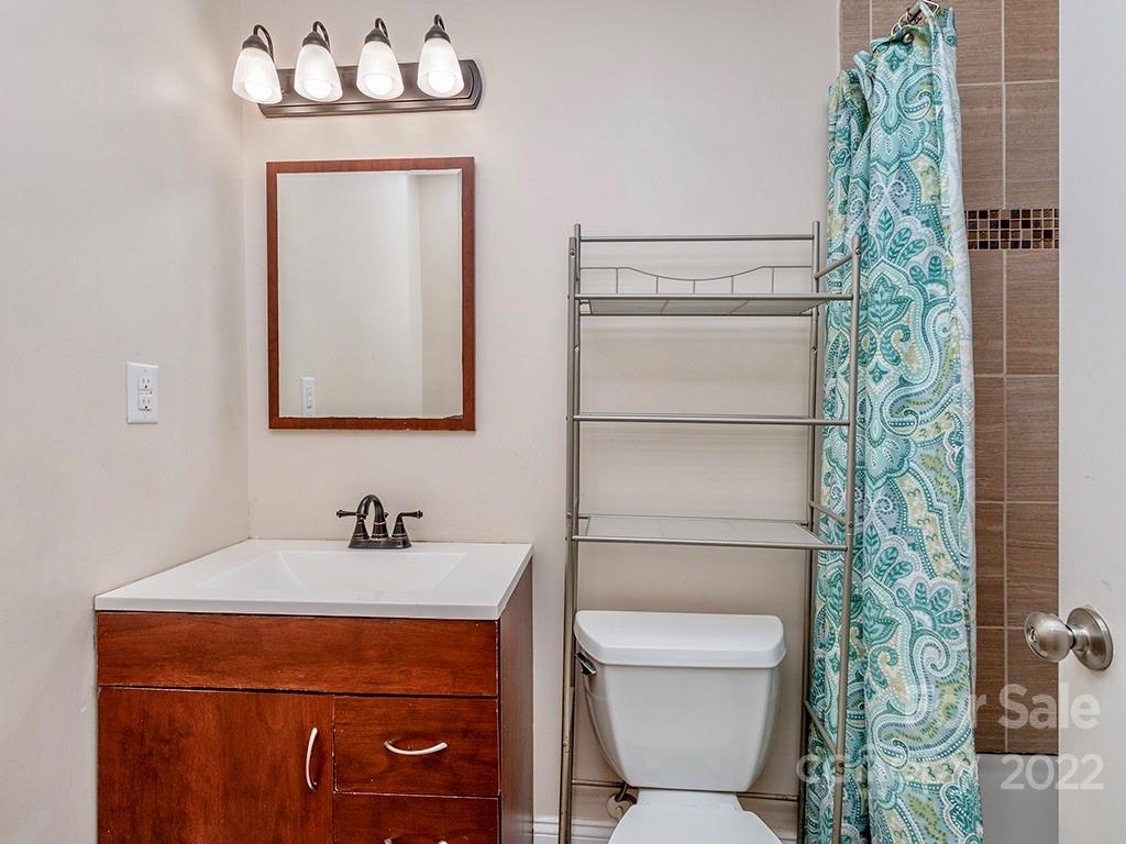 259 North Sharon Amity Road Charlotte, NC 28211 - Photo 18 of 27 a bathroom with a toilet a sink and a mirror