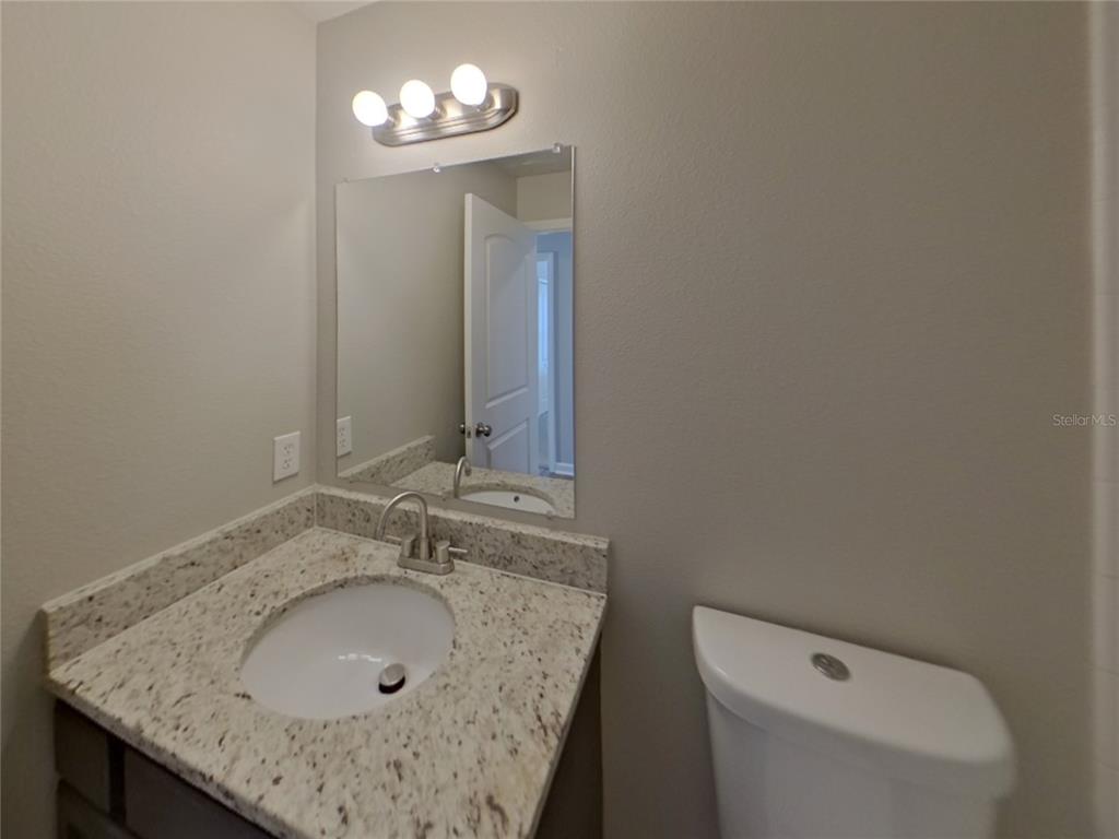 Undisclosed Address Riverview, FL 33579 - Photo 13 of 17 a bathroom with a granite countertop sink a toilet and a mirror