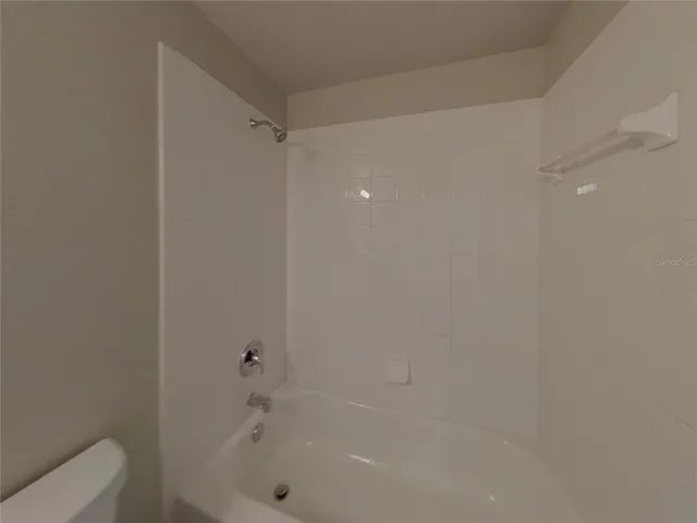 a view of a room with wooden floor a ceiling fan and window