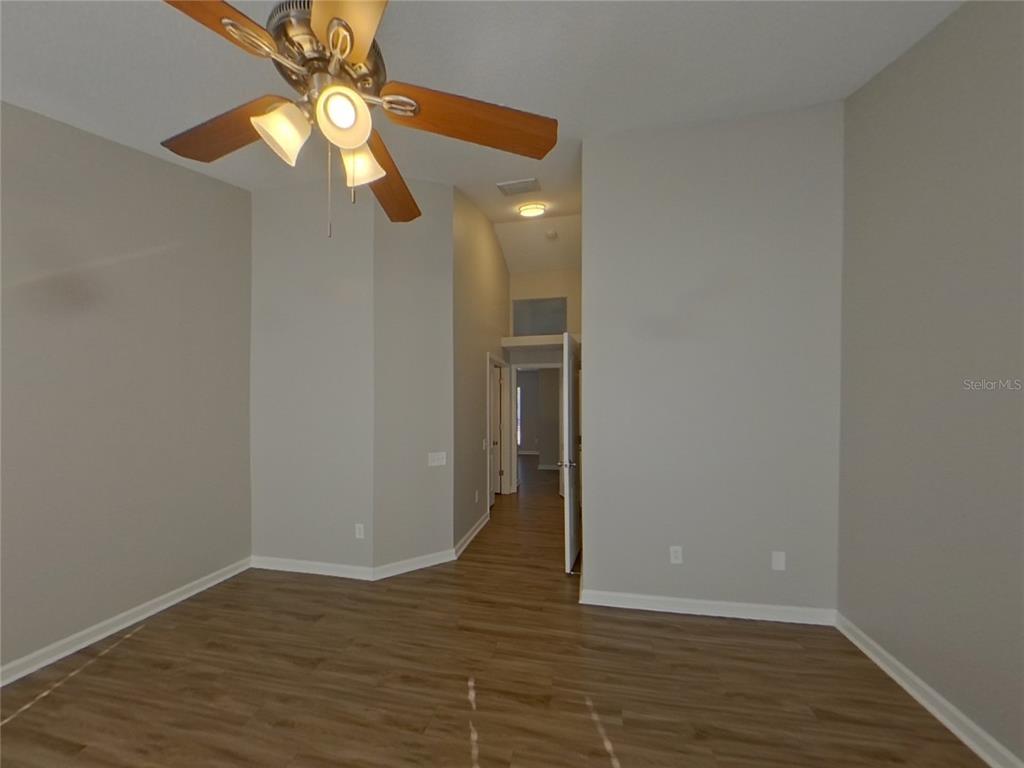 Undisclosed Address Riverview, FL 33579 - Photo 7 of 17 a view of an empty room with wooden floor and a ceiling fan