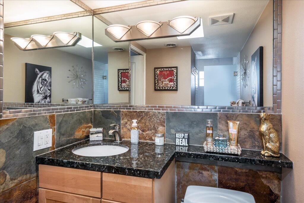 800 East Cottonwood Road, Unit 2 Palm Springs, CA 92262 - Photo 12 of 29 a bathroom with a granite countertop sink a mirror and vanity