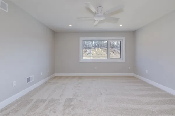 an empty room with windows and fan