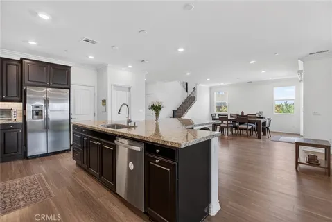 a kitchen with stainless steel appliances granite countertop a sink stove and wooden floor