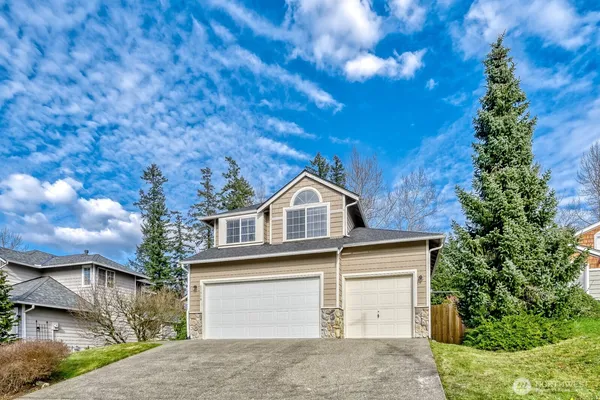 a front view of a house with a yard and garage