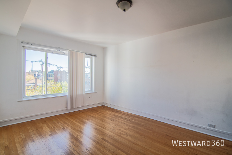 7833 South Kingston Avenue, Unit 2 Chicago, IL 60649 - Photo 5 of 15 an empty room with wooden floor and windows