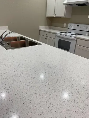 a kitchen with granite countertop a sink and a stove