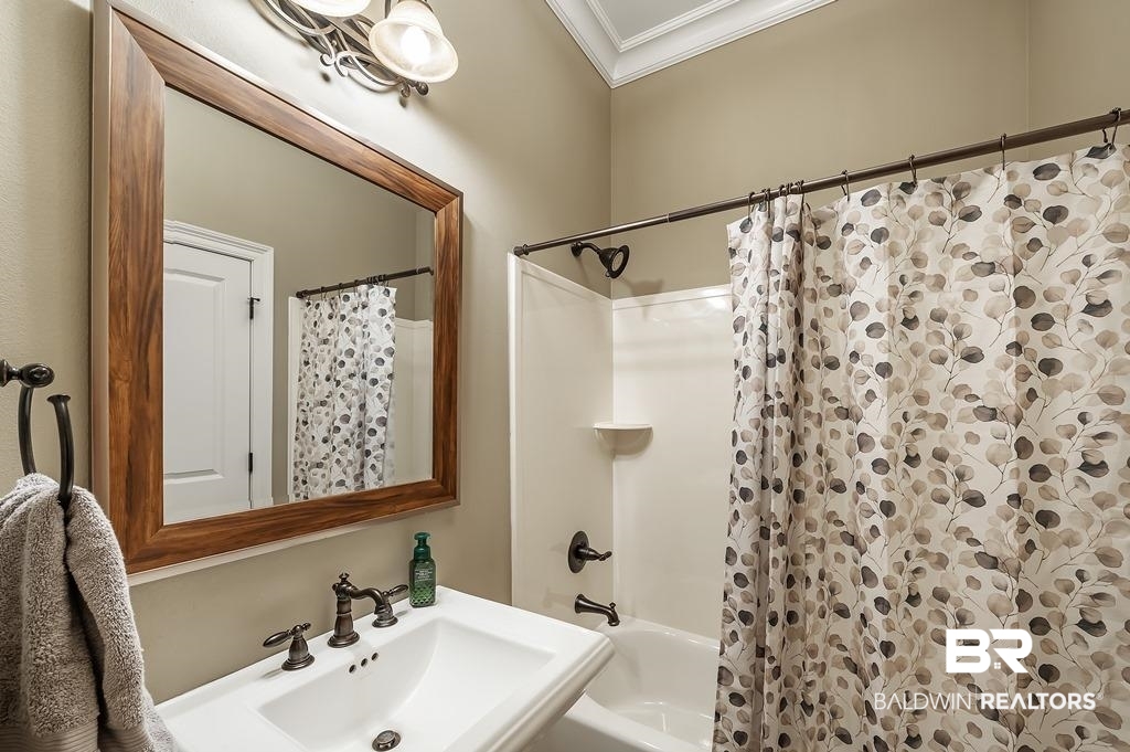 30014 Dolive Ridge Daphne, AL 36527 - Photo 14 of 57 Bathroom with crown molding, sink, and shower / bathtub combination with curtain