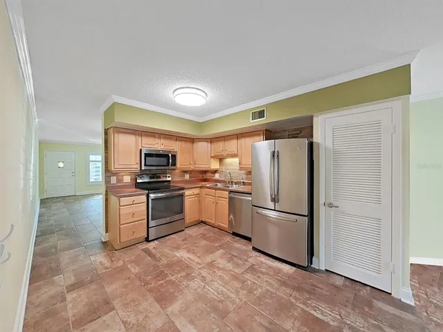 a kitchen with granite countertop a refrigerator and a stove top oven