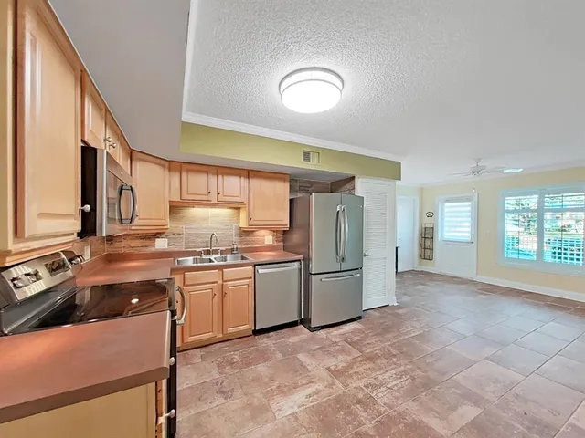 a kitchen with stainless steel appliances granite countertop a stove a sink and a refrigerator