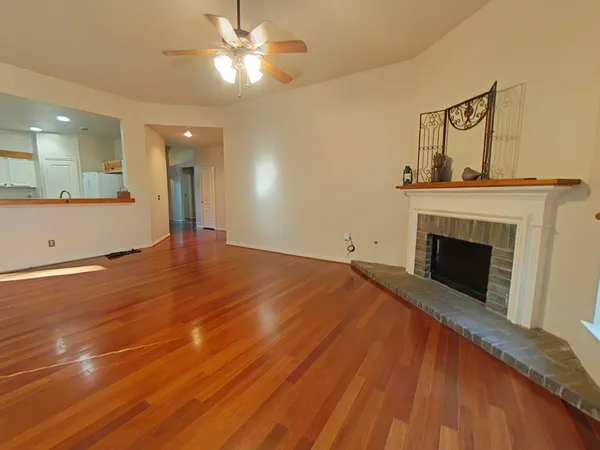 a view of empty room with wooden floor and fireplace