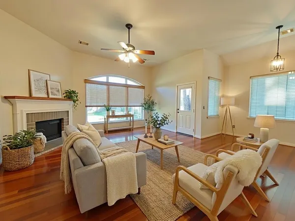 a living room with furniture a fireplace and a chandelier