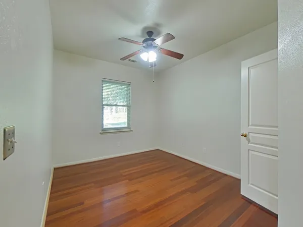 a view of empty room with wooden floor