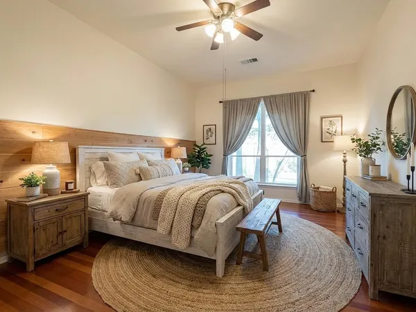 a bedroom with a bed a chandelier and a dresser