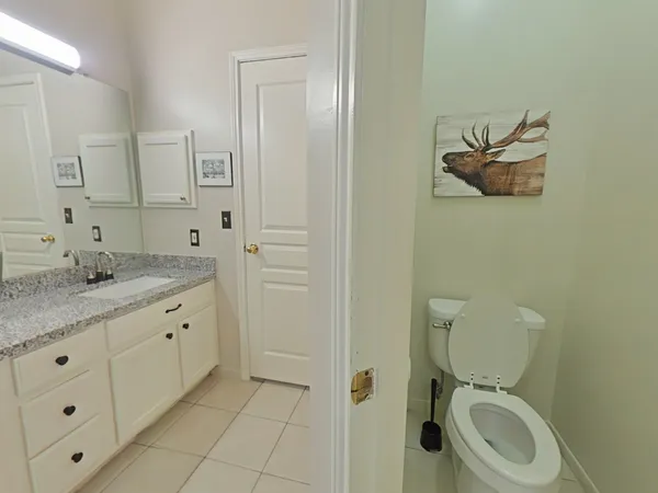a bathroom with a granite countertop toilet and a sink