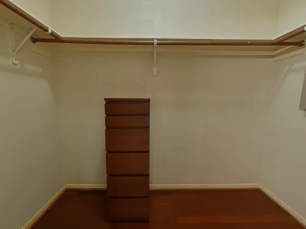a view of walk in closet with empty racks
