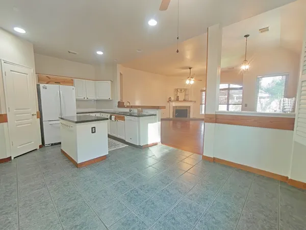 a large kitchen with stainless steel appliances granite countertop a stove a sink dishwasher and a refrigerator