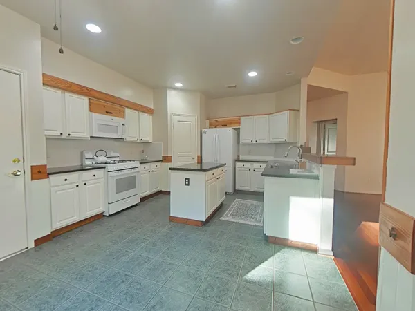 a kitchen with white cabinets and white appliances