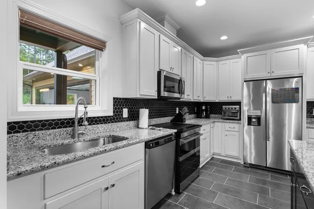 a en suite bathroom with a granite countertop sink and a mirror