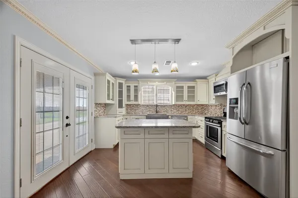 a kitchen with kitchen island white cabinets and stainless steel appliances