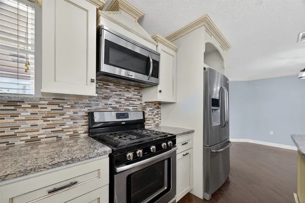 a kitchen with stainless steel appliances white cabinets and a stove top oven