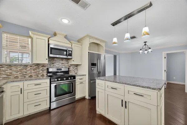 a kitchen with white cabinets and appliances